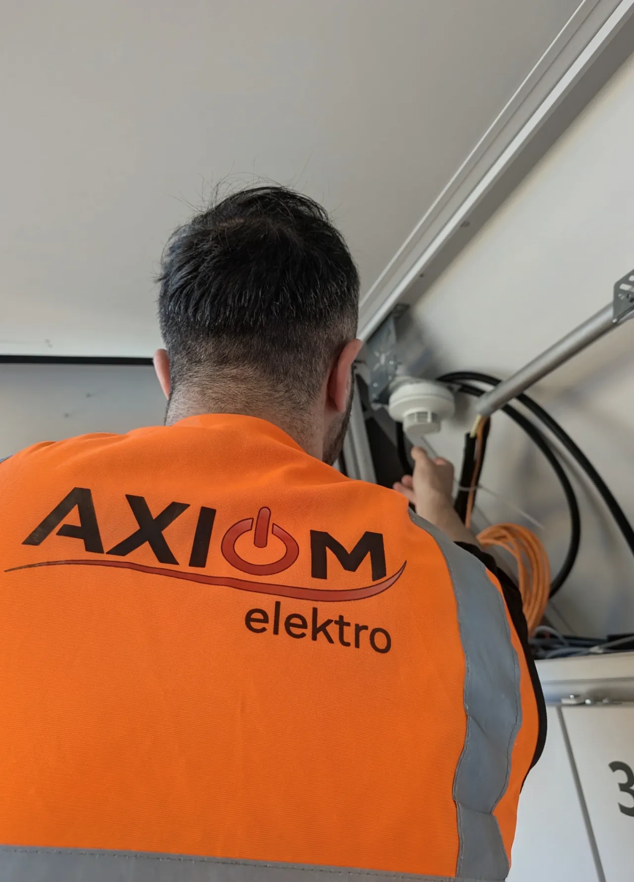 Axiom-Elektrofachmann installiert einen Sicherheitsmelder
