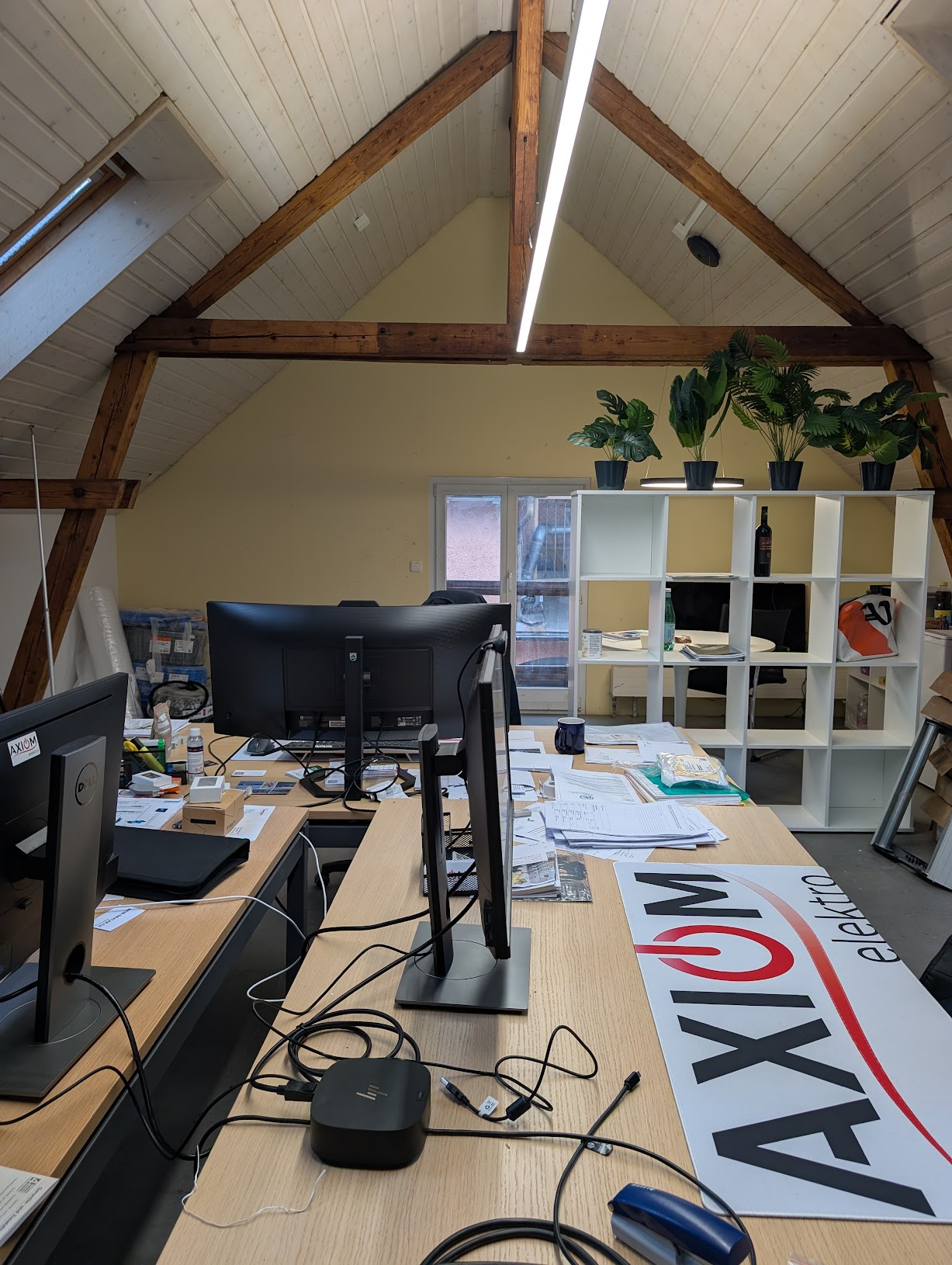 Büro der Axiom Elektro AG in Dübendorf mit Arbeitsplätzen unter Holzdachstuhl